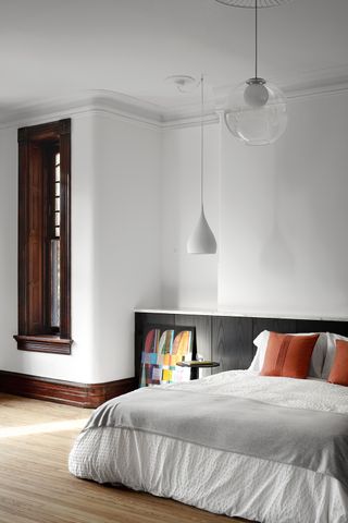white bedroom with low bed and wood shutters