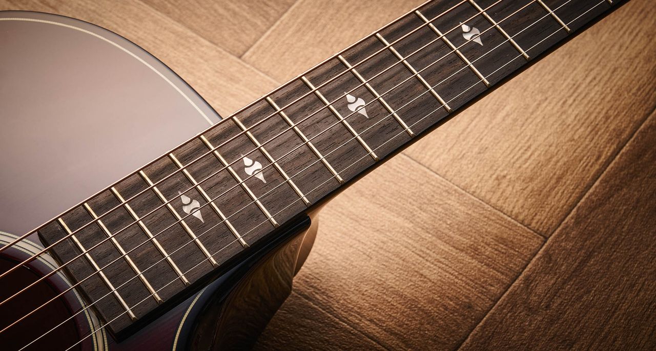 Taylor Builder&rsquo;s Edition 514ce Kona Burst pictured against a wooden floor and patterned rug.
