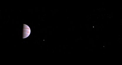 The view of Jupiter and three of its moons, as captured by the Juno spacecraft.