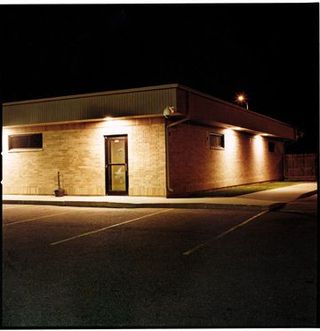 a building at night with a parking lot
