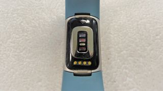 Bagsiden af Fitbit Charge 5, der viser optisk sensor og opladningsstik