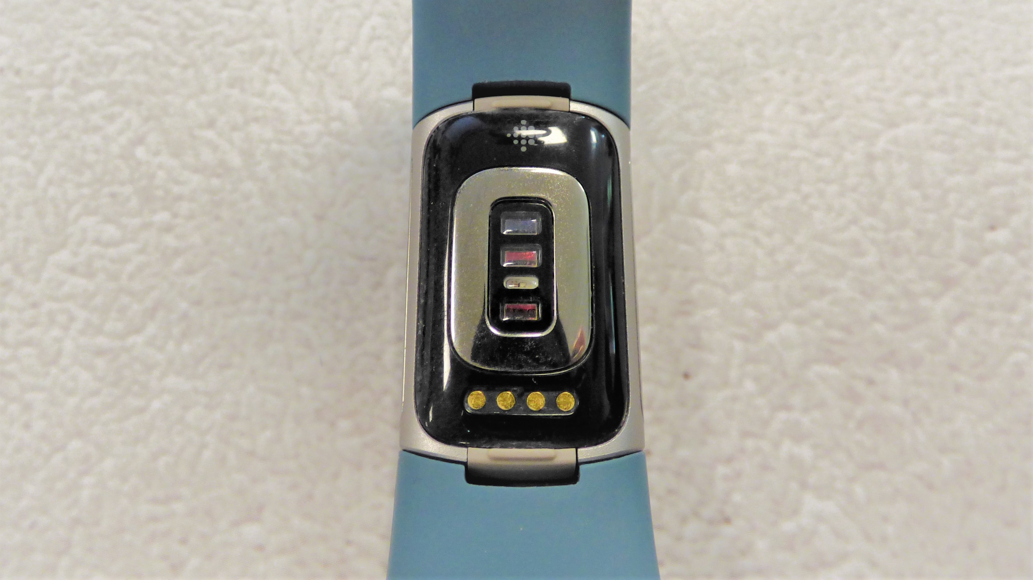 Back of Fitbit Charge 5, showing optical sensor and charging connectors