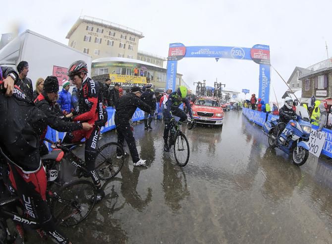 Riders stop for warm clothes atop the Stelvio