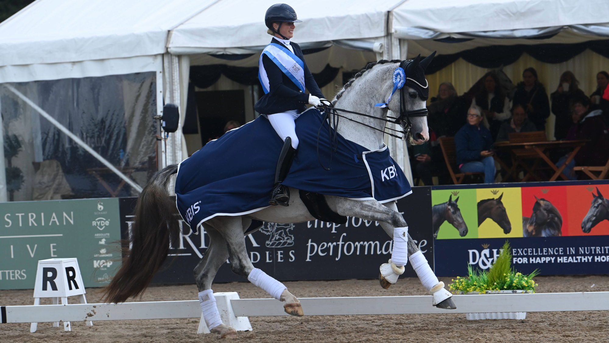 Sadie Smith rides River Rise Onassis in canter, wearing a KBIS rug, at the LeMieux National Dressage Championships.