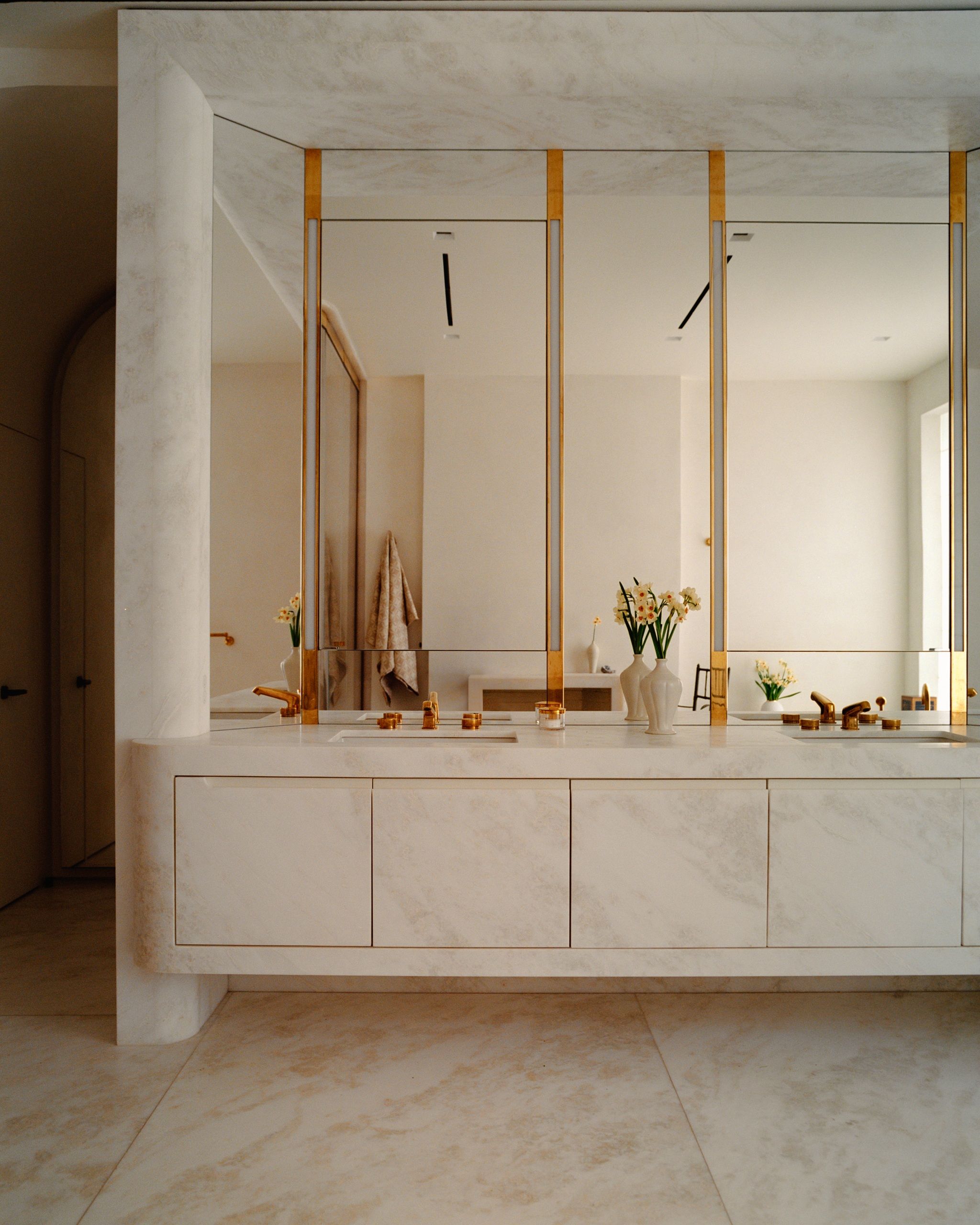 a bathroom with large mirrors and a stone built in vanity