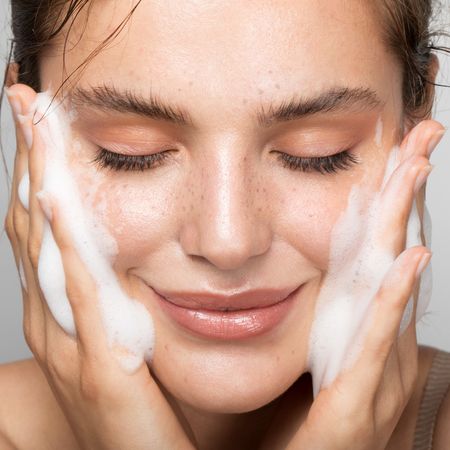 Best Cleanser: Woman with bright glowy skin and eyes closed