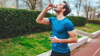 a male runner biting into a snack bar 
