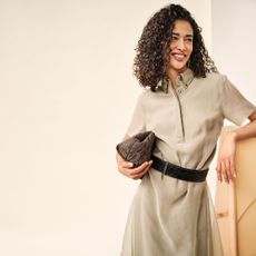 Woman wearing The Outnet beige dress leaning on frame