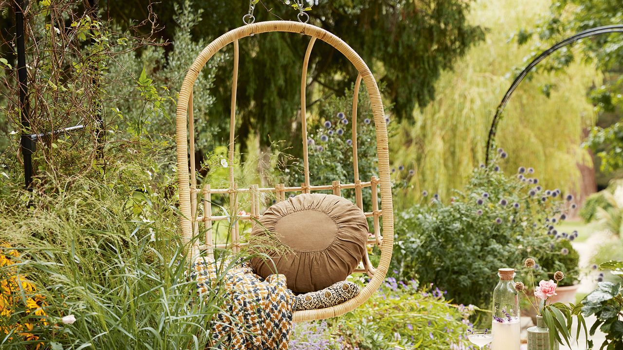 Hanging chair surrounded by plants in garden