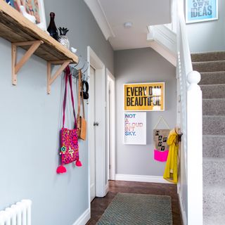 Grey hallway with high shelves and colourful accessories