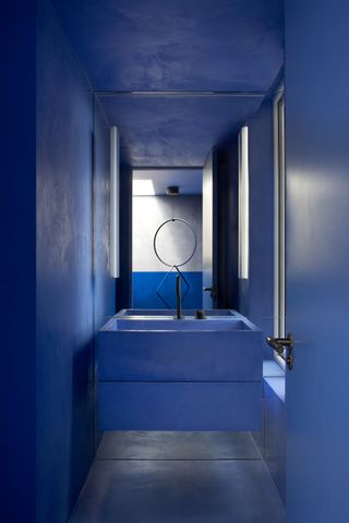 A bathroom drenched in cobalt blue tones