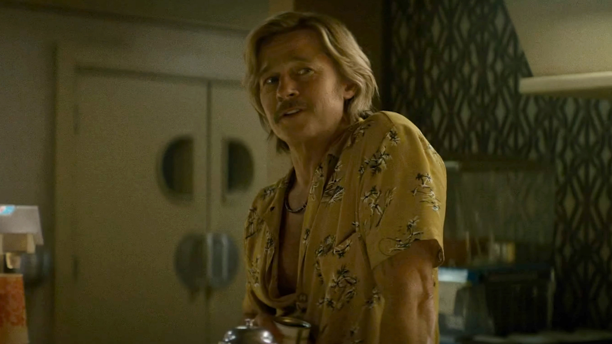 Brad Pitt as Cliff Boot, sporting a yellow opened Hawaiian shirt and a mustache, starring in Adventures of Cliff Booth (2026).