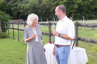 Camilla, Duchess of Cornwall samples some wine with owner of Llanerch Vineyard, Ryan Davies during a visit to Llanerch Vineyard on July 07, 2021 in Pontyclun, Wales