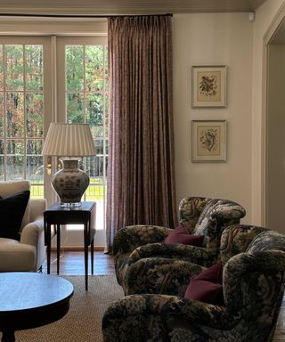 summer living room with large french doors and upholstered armchairs with vintage furniture