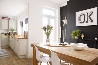 dining room with a black feature wall and a shaker style kitchen