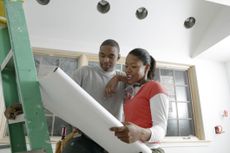 couple looking at blueprints and planning a home addition 
