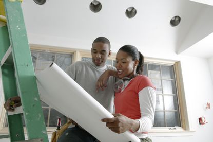 couple looking at blueprints and planning a home addition 