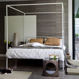 bedroom with white bed and designed cushion brown wall and grey floor