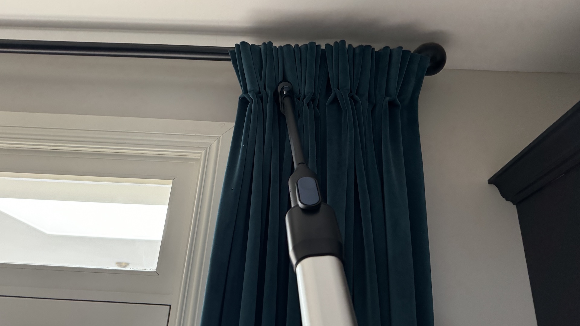 Levoit LVAC-300 vacuum with Crevice tool being used to clean curtains