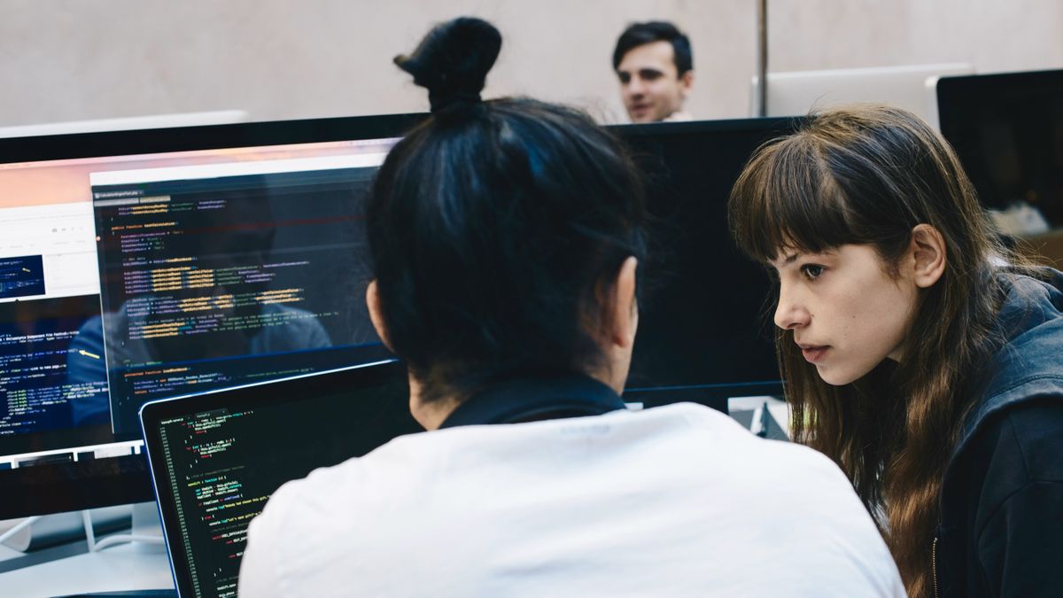 Two software developers talking at their desks