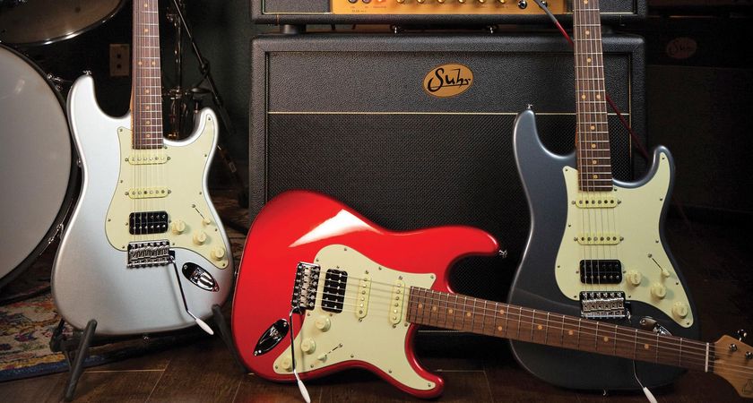 Three Suhr s-styles photographed in front of a Suhr SL series tube amp