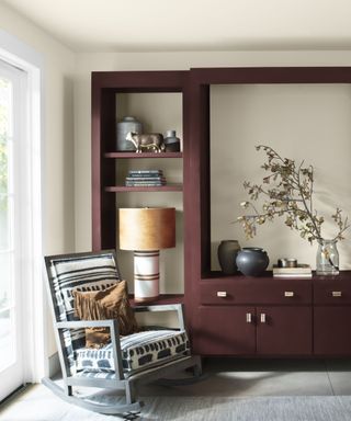 shelving painted in benjamin moore's new london burgundy in a neutral home with a rocking chair