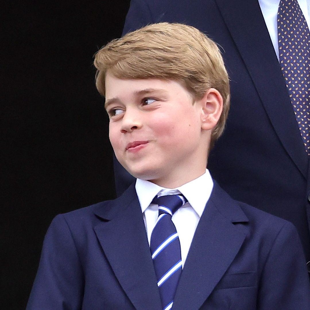 King Charles, Queen Elizabeth wearing bright green, and Prince George stand on the Buckingham Palace balcony