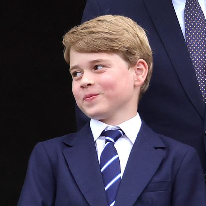 King Charles, Queen Elizabeth wearing bright green, and Prince George stand on the Buckingham Palace balcony