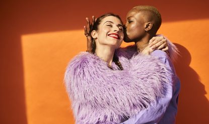 Colourful studio portrait of two women, dating, plan a date