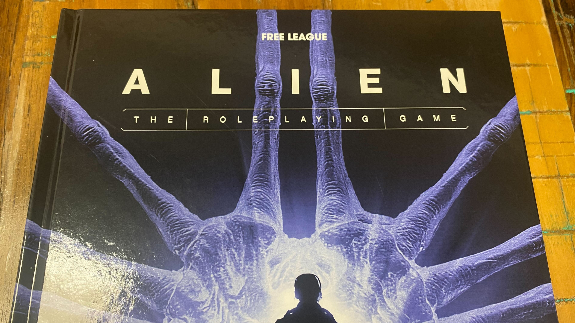 Alien RPG Evolved Edition rulebook laid out on a wooden table