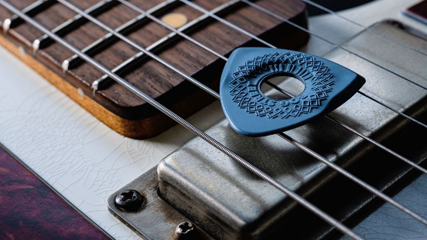 Closeup of a Bog Street guitar pick on top of guitar strings