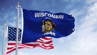 Image of Wisconsin's state flag flying in front of the US flag