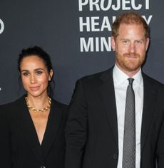 Prince Harry and Meghan Markle wearing black suits