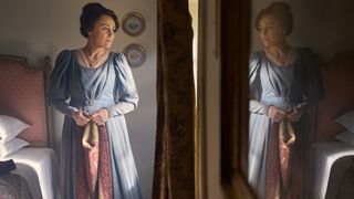 Keeley Hawes in a blue dress as Cassandra Austen is reflected in a mirror in Miss Austen.