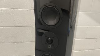 SVS Ultra Evolution Tower floorstanding speakers against white brick wall, close up on drivers