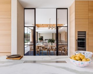 A modern kitchen with marble coutertop and Crittall doors