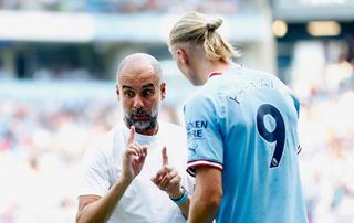 Pep Guardiola, Manager of Man City interacts with Erling Haaland of Manchester City during the Premier League match between Manchester City and AFC Bournemouth at Etihad Stadium on August 13, 2022 in Manchester, England.