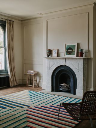 Living room with fireplace, neutral painted walls and geometric rug