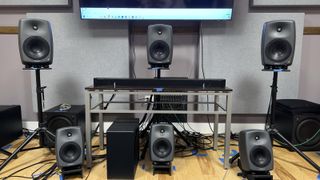 An early prototype of a Samsung soundbar photographed on a table surrounded by Genelec studio monitors