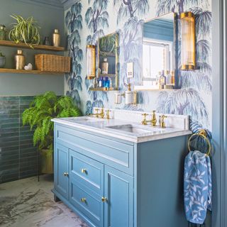 a bathroom with bold wallpaper and tiled walls, a double vanity unit and a pair of matching mirrors and wall lights