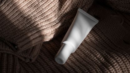 Close up of unbranded moisturiser on a knitted jumper