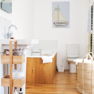 white bathroom with wooden floor and bathtub