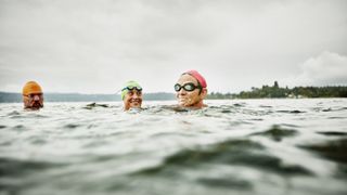 Smiling swimmers resting during open water swim 