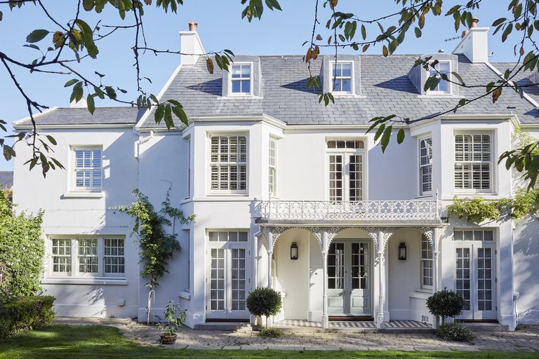 white coastal home with elegant balcony
