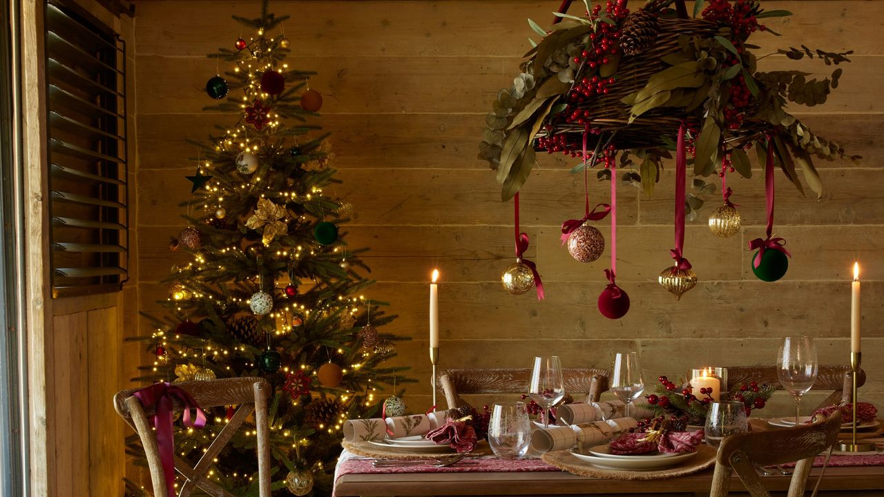 Christmas-decorated dining table with a Christmas tree in the background