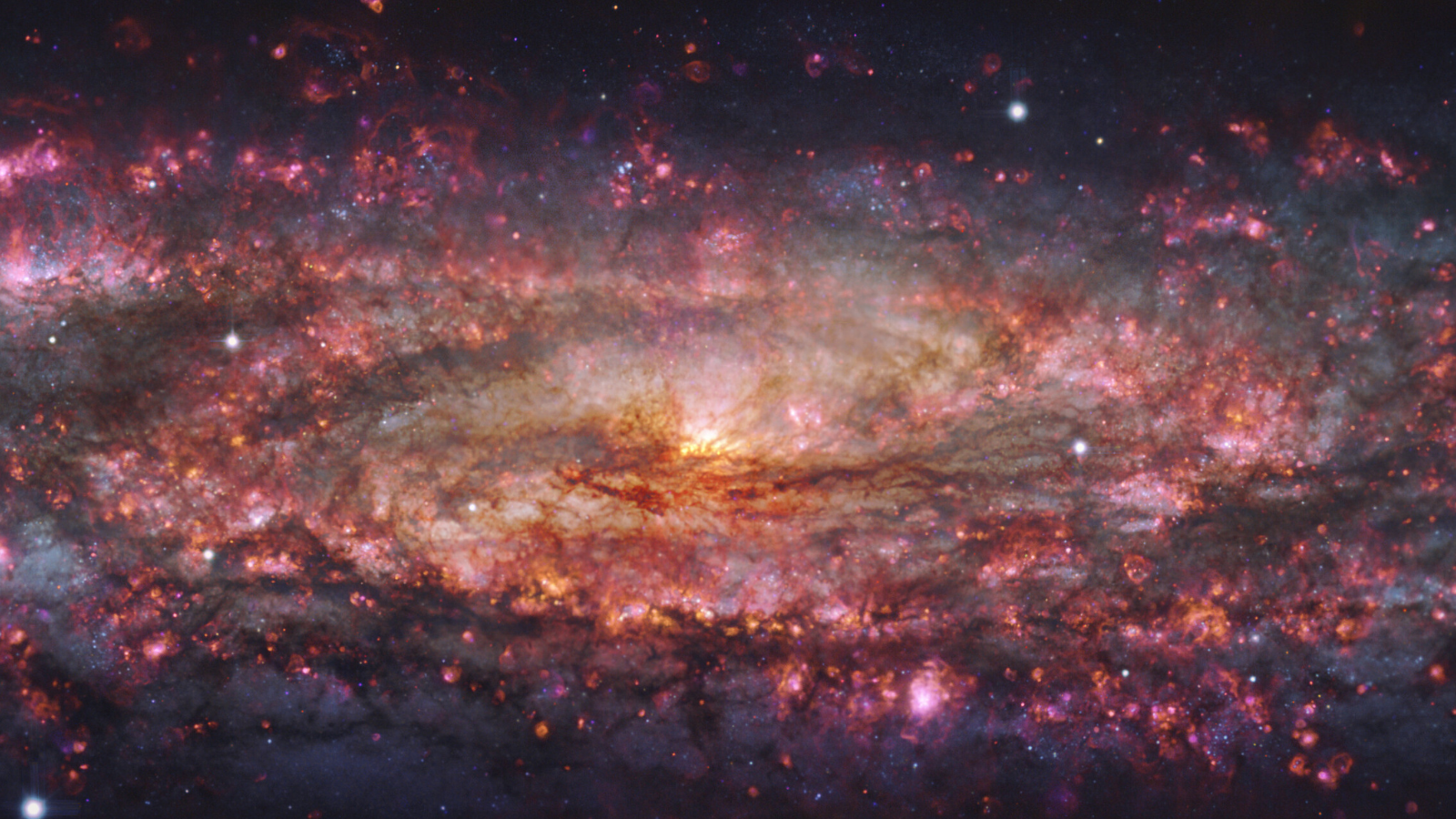 Zoomed-in image of a galaxy, with reddish and purple patches scattered throughout