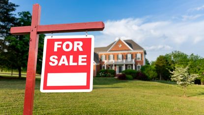 House for sale sign with house in background