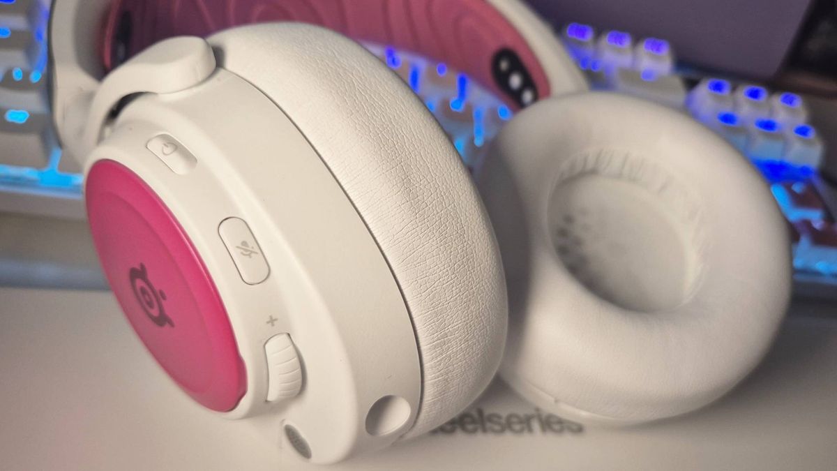 Photo of the white SKU SteelSeries Arctis Nova Pro Wireless gaming headset, taken by Rosalie Newcombe, with SteelSeries pink accessories attached.