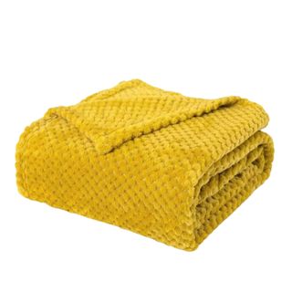 A folded yellow fuzzy blanket