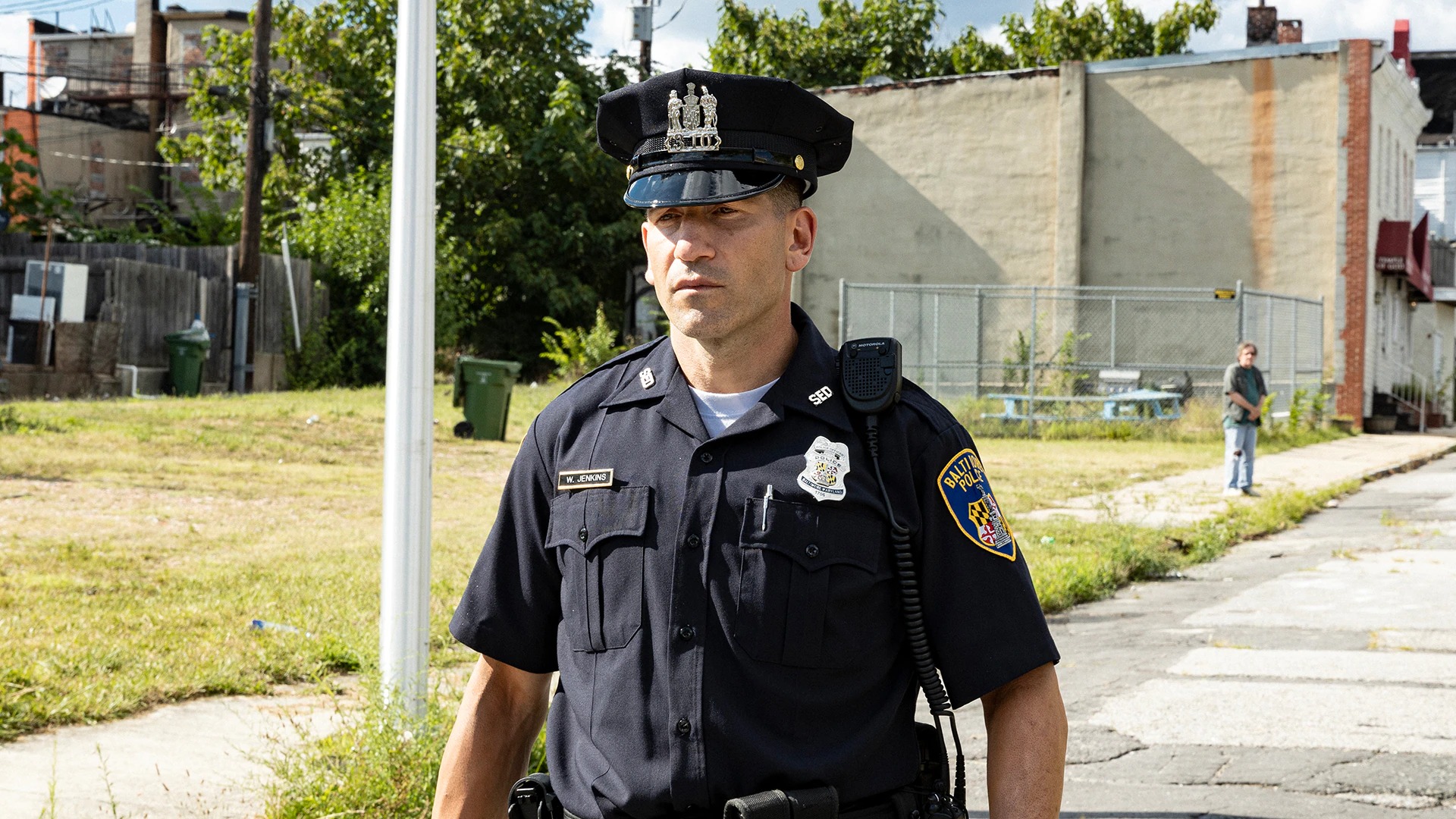 Jon Bernthal går på en gade i politiuniform i serien We Own This City